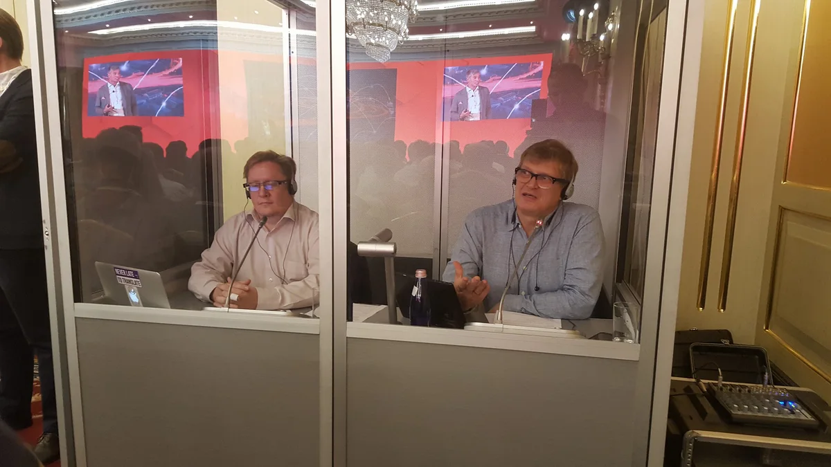 Two interpreters working in a simultaneous interpreting booth